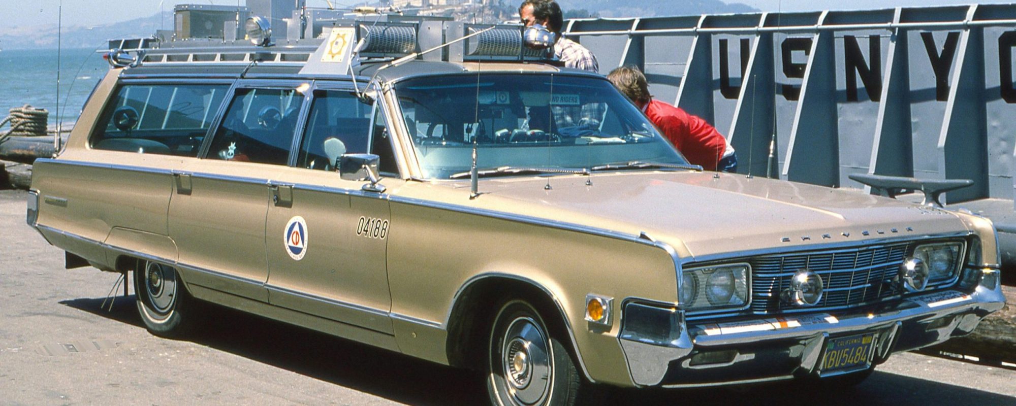 Classic Chrysler Town & Country at a harbor with retro style and picturesque backdrop.