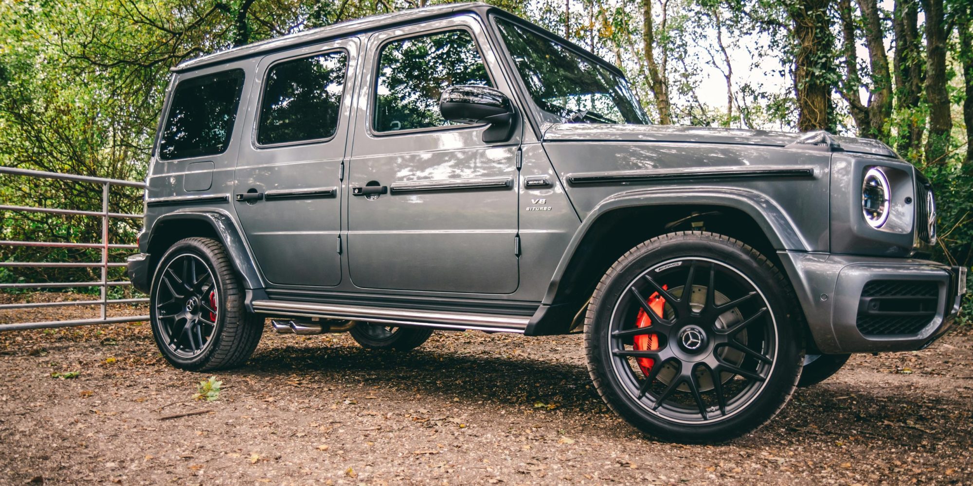 A luxurious Mercedes-Benz SUV parked in a scenic wooded area G-Wagon. by Lloyd Freeman